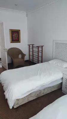 a bedroom with two beds and a chair at Zoute Zoene in Kleinmond
