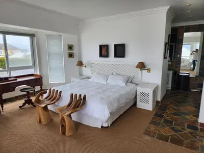 a bedroom with a large bed and a piano at Zoute Zoene in Kleinmond
