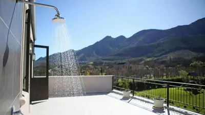 a shower on a balcony with a view of mountains at Château Famille in Franschhoek