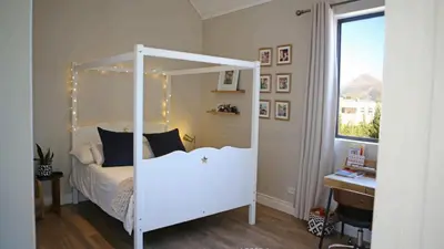 a bedroom with a white canopy bed with lights at Château Famille in Franschhoek
