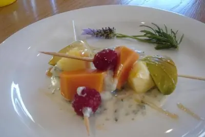a plate of food with fruit on a table at Baleia Guest Lodge in Hermanus