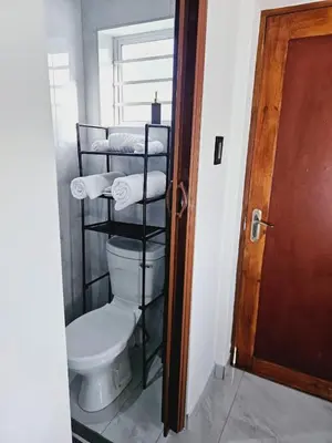 a bathroom with a toilet and a rack of towels at En suite in Cape Town
