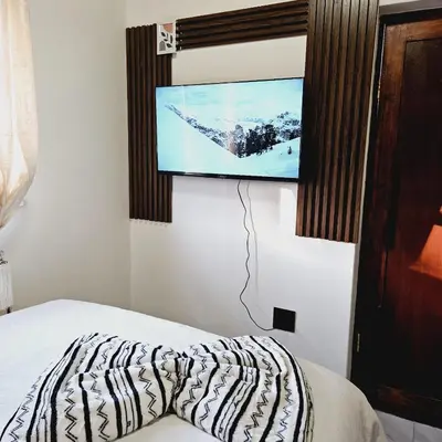 a bedroom with a bed and a flat screen tv at En suite in Cape Town