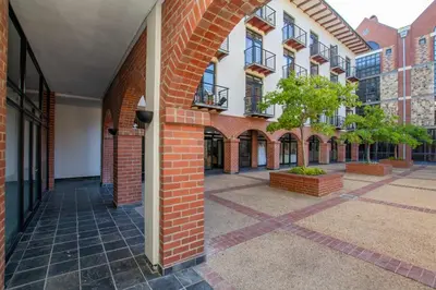 an empty courtyard of a brick building with a tree at CAG Bosman's Crossing Stellenbosch in Stellenbosch