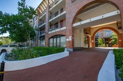 a brick building with an archway next to a sidewalk at CAG Bosman's Crossing Stellenbosch in Stellenbosch