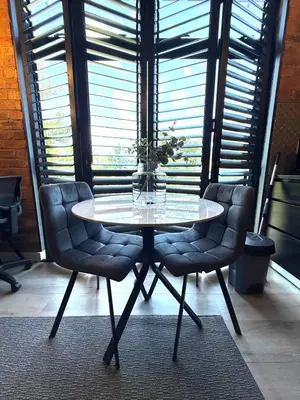 a table with two chairs and a vase with flowers on it at CAG Bosman's Crossing Stellenbosch in Stellenbosch