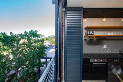 a kitchen with a balcony with a view of a street at CAG Bosman's Crossing Stellenbosch in Stellenbosch