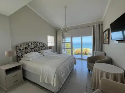 a bedroom with a bed and a view of the ocean at Vermont Hermanus Flatlet in Hermanus