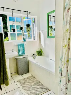 a bathroom with a tub and a sink at Sunny Poolside Escape in Somerset West in Somerset West
