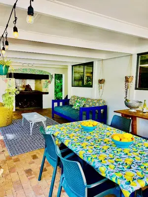a living room with a table and a couch at Sunny Poolside Escape in Somerset West in Somerset West