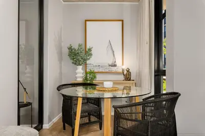 a dining room with a glass table and chairs at Sunbird Apartments in Cape Town