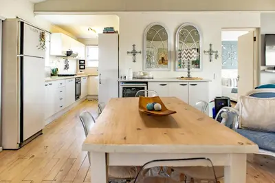 a kitchen and dining room with a wooden table at Upper Dunes Apartment in Pringle Bay