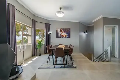 a dining room with a table and chairs at 75 on Chapman in Gordonʼs Bay