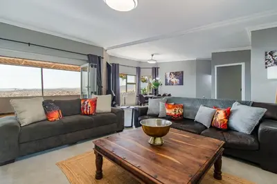 a living room with couches and a wooden table at 75 on Chapman in Gordonʼs Bay