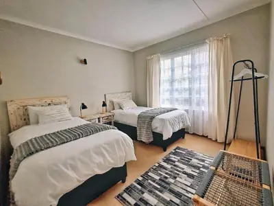 a bedroom with two beds and a window at Swannie Creek in Grabouw