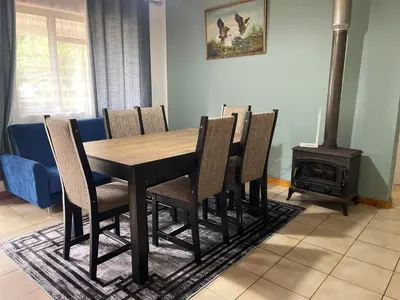 a dining room table with chairs and a wood stove at The Garden House in Hermanus