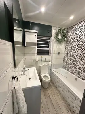 a bathroom with a toilet and a sink and a tub at 29 on Windsor-2 Bedroom House in Silver Sands