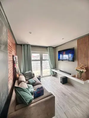 a living room with a couch and a flat screen tv at 29 on Windsor-2 Bedroom House in Silver Sands