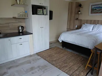 a bedroom with a bed and a kitchen with a sink at Place of Old D in Eersterivier
