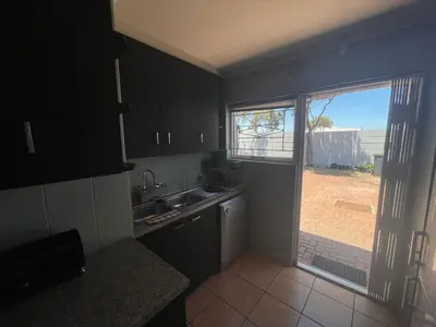 a kitchen with a sink and a door to a yard at Vynhubia in Monte Vista
