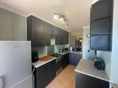 a kitchen with black cabinets and a white refrigerator at Vynhubia in Monte Vista