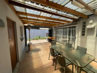 a patio with a glass table and chairs on a deck at Vynhubia in Monte Vista