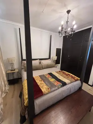 a large bed in a room with a chandelier at 4 Molteno in Hermanus