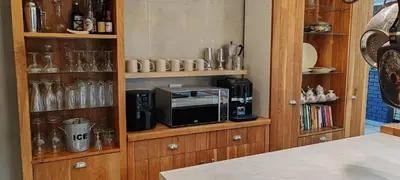 a kitchen with a cabinet with a microwave and glasses at 4 Molteno in Hermanus