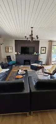 a living room with black leather couches and a fireplace at 4 Molteno in Hermanus