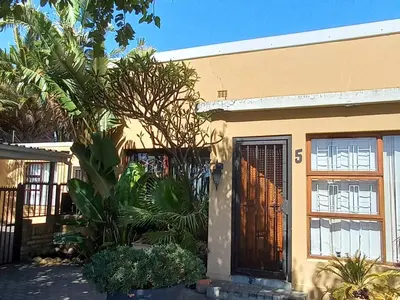 a house with a brown door and some plants at A Stone's Throw away in Cape Town