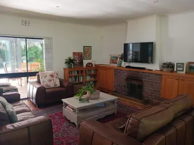 a living room with couches and a fireplace and a tv at Spacious Family Home - Windsor Retreats in Somerset West