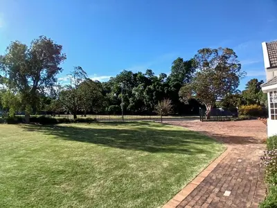 a large grassy area with trees in the background at Spacious Family Home - Windsor Retreats in Somerset West
