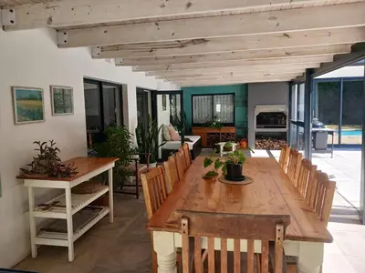 a dining room with a wooden table and chairs at Spacious Family Home - Windsor Retreats in Somerset West