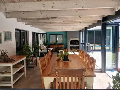 a dining room with a wooden table and chairs at Spacious Family Home - Windsor Retreats in Somerset West