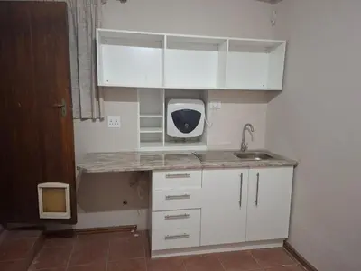 a small kitchen with white cabinets and a sink at MDA Myburgh in Brackenfell