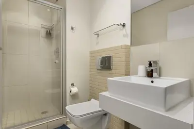 a bathroom with a sink and a toilet and a shower at La Cabina 105 in Cape Town