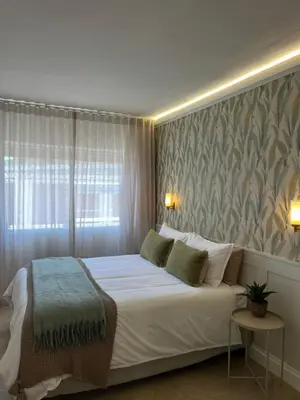 a bedroom with a white bed with a large window at Nomads Hermanus in Hermanus