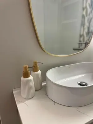 a white bathroom with a sink and a mirror at Nomads Hermanus in Hermanus