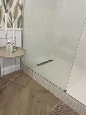a shower with a table next to a table with a candle at Nomads Hermanus in Hermanus