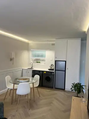 a small kitchen with a table and chairs in a room at Nomads Hermanus in Hermanus