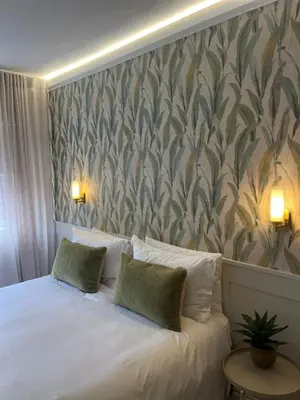 a bedroom with a white bed with two pillows at Nomads Hermanus in Hermanus