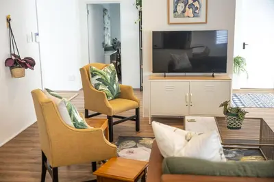 a living room with a tv and two chairs at 5 Bedroom Family Home with Private Apartment in Hermanus