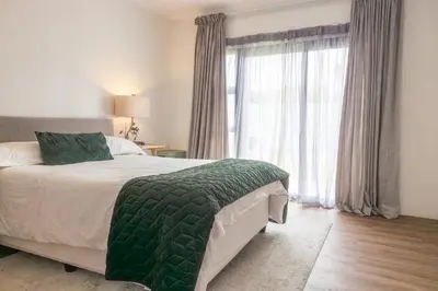 a bedroom with a bed and a large window at 5 Bedroom Family Home with Private Apartment in Hermanus