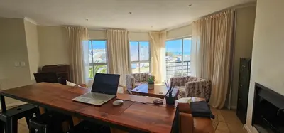 a living room with a table with a laptop on it at Kite Surfers Haven in Cape Town
