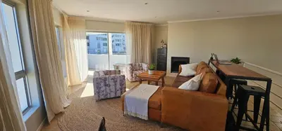 a living room with a large brown couch in a room at Kite Surfers Haven in Cape Town