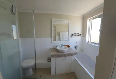 a bathroom with a sink and a toilet and a shower at Kite Surfers Haven in Cape Town