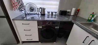 a kitchen with a washing machine in a counter at Grey Vine Cottage - Flatlet in Cape Town