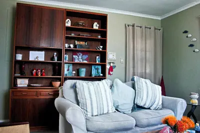 a living room with a couch and a book shelf at Fijnbos - Something-Els in Rooiels