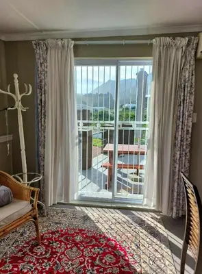 a living room with a large sliding glass door at Fijnbos - Something-Els in Rooiels