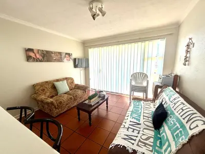 a living room with a couch and a table at 111 Hermanus beach club in Hermanus